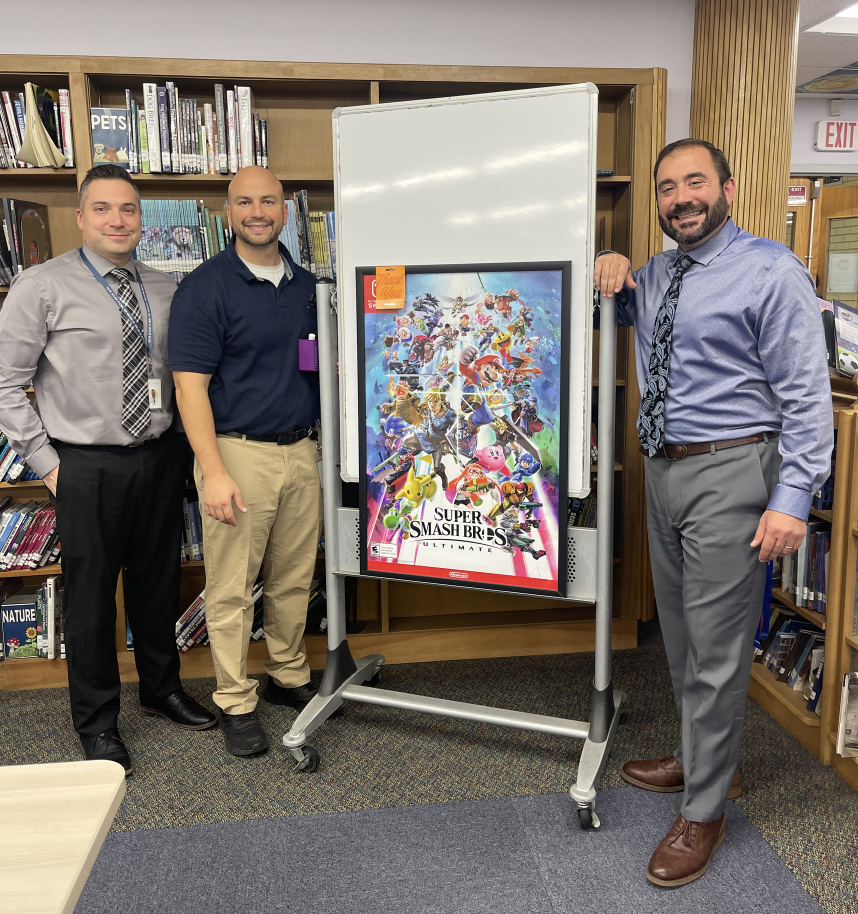 Advisers Mr. Mitchell, Mr. Maltese and Mr. Gagnon display the grand prize with anticipation for their fourth annual tournament.